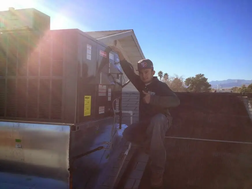 HVAC technician performing Heat Pump Repair on a rooftop unit in Mount Carmel